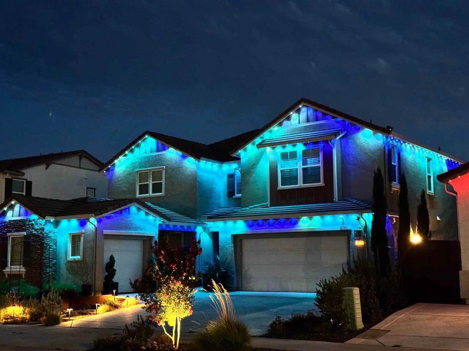 Blue and teal permanent roofline lighting on a Florida home